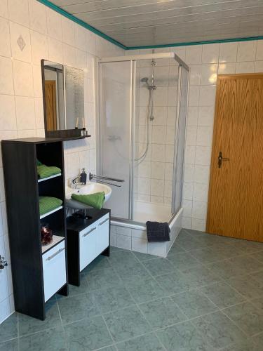 a bathroom with a shower and a sink and a tub at Ferienwohnung Römmer in Ströbeck