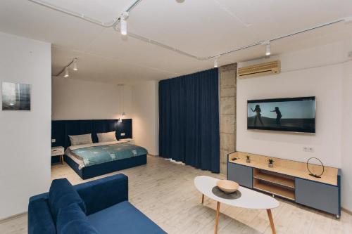 uma sala de estar com um sofá azul e uma cama em loft Apartmen em Sumy