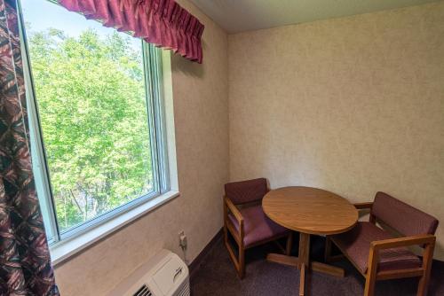 a room with a table and chairs and a window at Willabee's Motel in Brimley