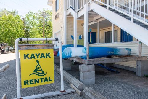 a yellow and blue kayak rental sign in front of a house at Willabee's Motel in Brimley
