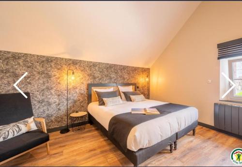 a bedroom with a large bed and a couch at ATELIER 19 Maison d'Hôtes in Varesnes