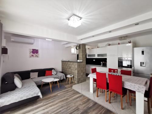 Il dispose d'une cuisine et d'un salon avec un canapé et une table. dans l'établissement Apartment Baćo, à Podstrana