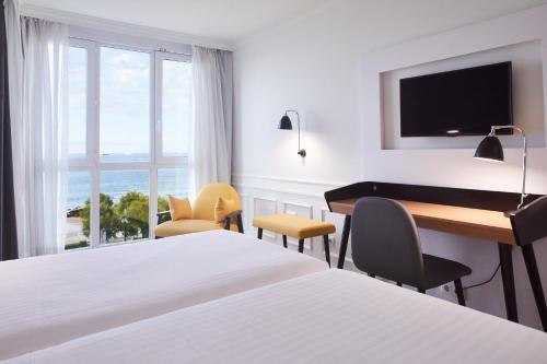 a hotel room with two beds and a television at Silken Río Santander in Santander