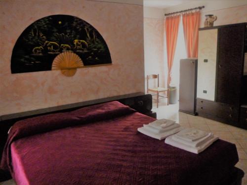 a bedroom with a bed with two towels on it at L'Elefantino - Bed and Book in Roccasparvera