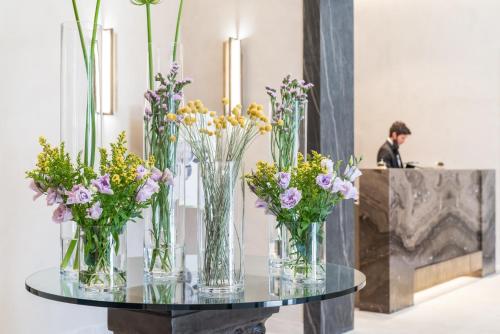 a group of vases filled with flowers on a table at Hotel Firenze e Continentale in La Spezia