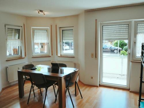 a dining room with a table and chairs and windows at Schöne Wohnung in Fürth