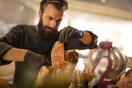 a man preparing a piece of food in a container at Valamar Riviera Hotel & Residence in Poreč