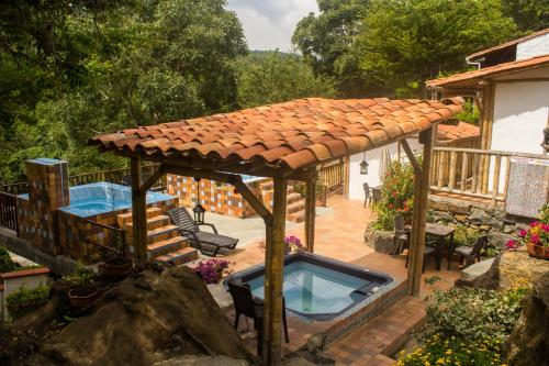 un patio con bañera de hidromasaje bajo el techo en Hotel Terrazas de la Candelaria, en San Gil