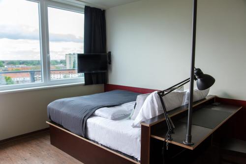 a bedroom with a bed and a large window at Base Apartments in Hamburg
