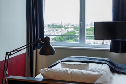 a bedroom with a bed and a large window at Base Apartments in Hamburg