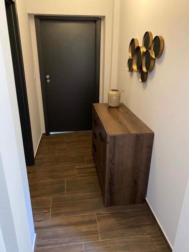a hallway with a black door and a wooden floor at Balkon Apartmanház Panzió in Balatonfüred