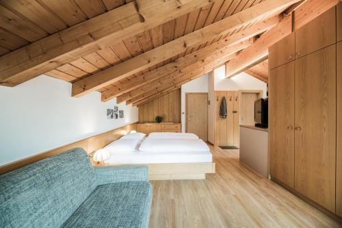 a bedroom with a bed and a couch at Appartements Sporting in Sesto