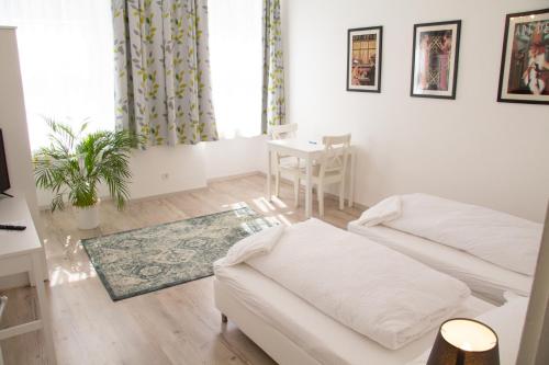 Una sala de estar blanca con un sofá y una mesa. en Vienna4you App 15 you are welcome, en Viena