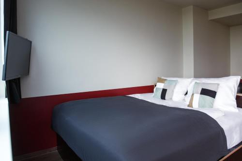 1 dormitorio con 1 cama y TV en la pared en Base Apartments, en Hamburgo