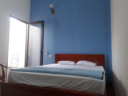 a blue bedroom with a bed with a blue wall at Bong Mai in Làng Dương