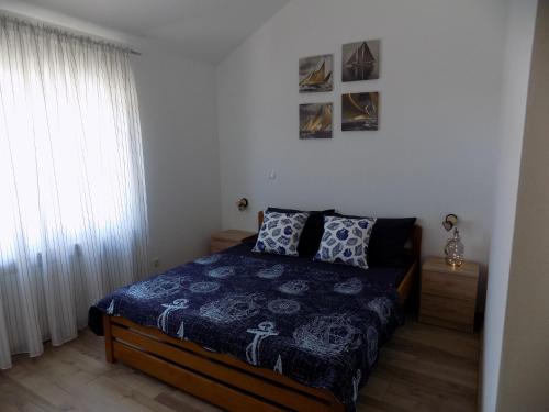 1 dormitorio con 1 cama con edredón azul y ventana en Villa Jukic Murter, en Murter