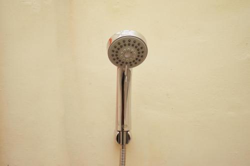 a shower head is hanging on a wall at KoolKost Syariah near T1 Juanda Airport 3 in Sidoarjo