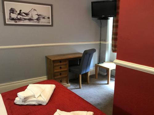 a room with a desk and a bed and a chair at Newcastle House Rothbury in Rothbury