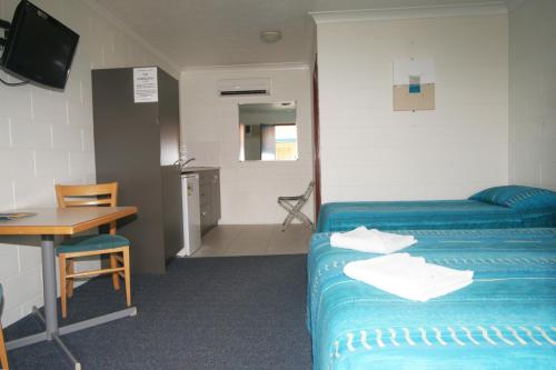 a hotel room with a bed and a table at Cedar Lodge Motel in Townsville