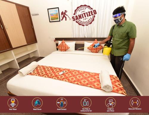 a man standing next to a bed in a room at Sree Service apartments in Tirupati