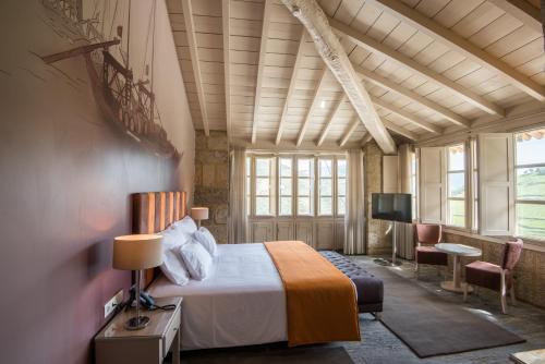 a bedroom with a bed and a flat screen tv at Vila Gale Douro Vineyards in Armamar