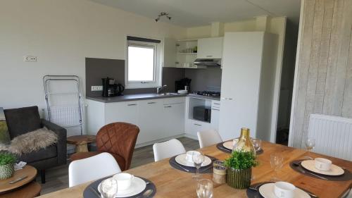 uma cozinha e sala de jantar com mesa e cadeiras em Cassandria Bad - luxe Glamping em Retranchement