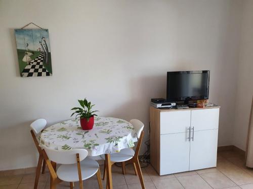 a dining room table with chairs and a tv on a cabinet at Apartments Adriatic in Korčula