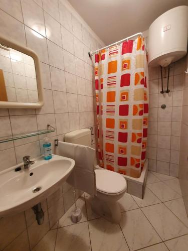 a bathroom with a toilet and a sink and a shower curtain at Apartments Adriatic in Korčula
