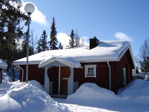 a house covered in snow next to a light pole at Fjällriket Baggården in Baggården