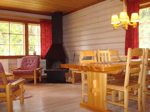 a dining room with a table and a fireplace at Fjällriket Baggården in Baggården