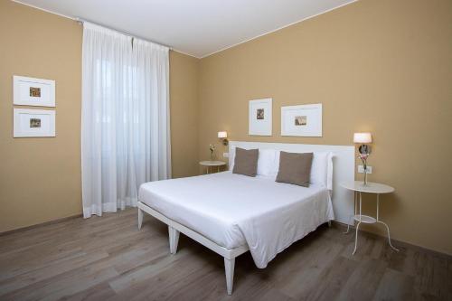 a bedroom with a white bed and two tables at Blu Hotel in Lavagna