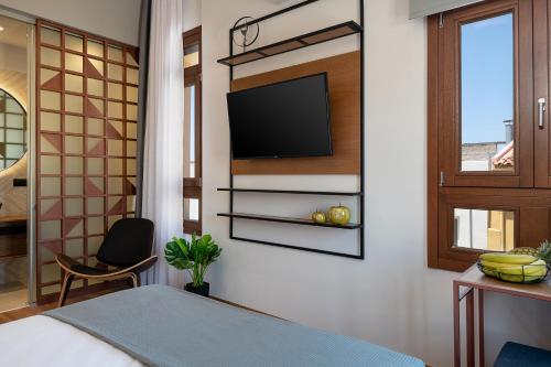 a bedroom with a bed and a tv on a wall at Camere Maritima in Chania Town