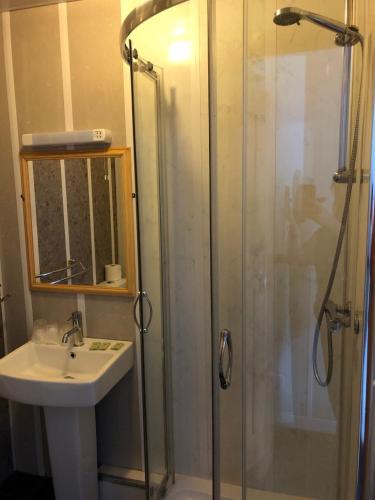 a bathroom with a shower and a sink at OYO The Bentleys Hotel in Newcastle upon Tyne
