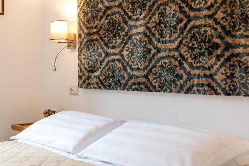 a bedroom with a bed with a painting on the wall at Karama in Dorgali