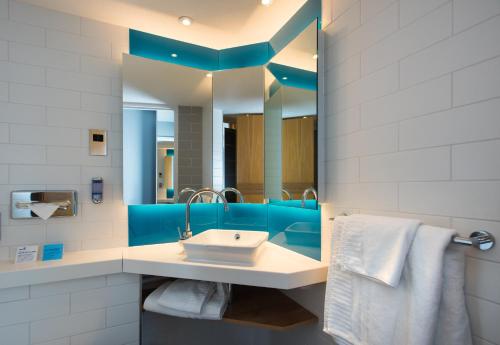 y baño con lavabo y espejo. en Holiday Inn Express Cardiff Bay, an IHG Hotel en Cardiff