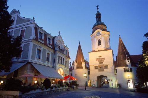 a building with a clock tower on a street at Gästehaus Familie Trachsler in Rohrendorf bei Krems