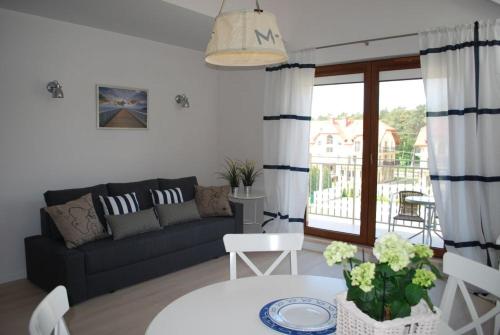 a living room with a couch and a table at Apartament Morski in Karwia