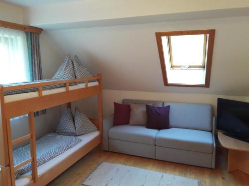 ドナースバッハヴァルトにあるBase-Camp Appartementの二段ベッドとソファが備わる客室です。