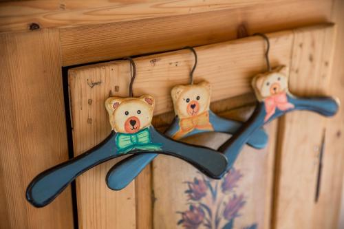 three teddy bears are hanging on a wall at KRALJICA ŠUME - Divjake Log Home in Hlevci
