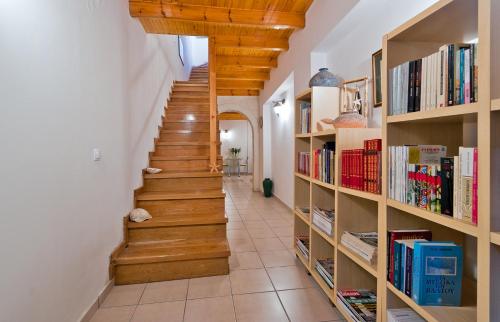 een hal met houten trappen en boekenplanken bij Odyssey House in Chania