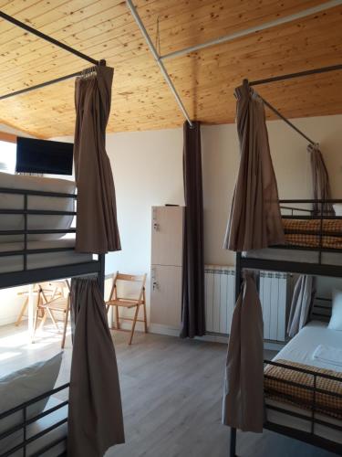 a room with three bunk beds in a house at O Cabalo Verde in Palas de Rei