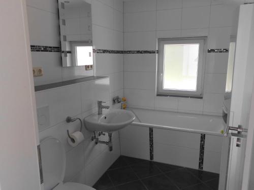 bagno bianco con lavandino e servizi igienici di Haus Astrid -Schwerin-Görries - a Klein Rogahn