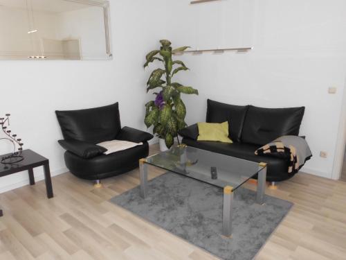 un soggiorno con divano nero e tavolo di Haus Astrid -Schwerin-Görries - a Klein Rogahn