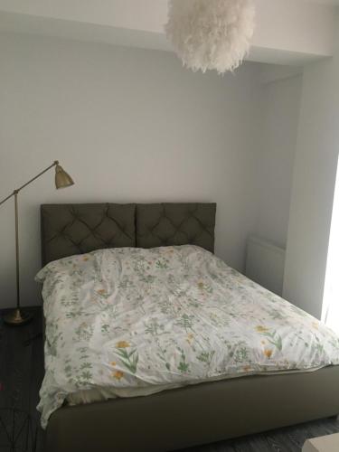 1 dormitorio con 1 cama con edredón de flores en True Modern - apartment, en Valea Lupului