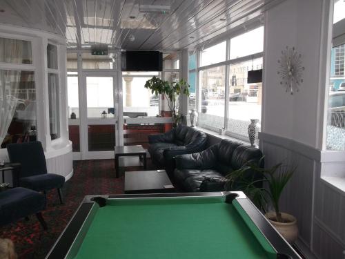 a pool table in a living room with leather furniture at Elmfield in Blackpool