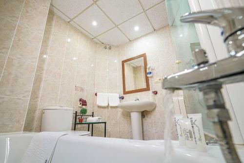 a bathroom with a sink, toilet and bathtub at Hotel Colón in Ronda