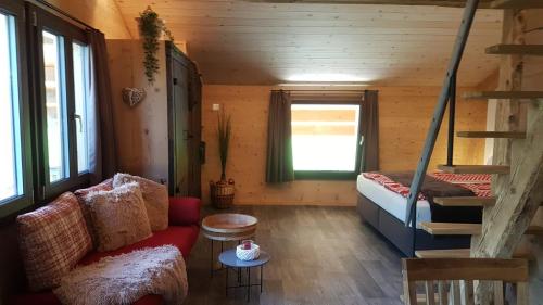 a room with a couch and a bed in a cabin at Chalet bei der Arve in Grindelwald