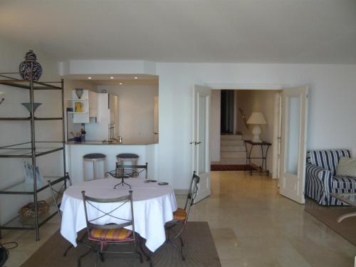 ein Esszimmer mit einem weißen Tisch und Stühlen in der Unterkunft Appartement Relais de la Reine Cannes Croisette in Cannes