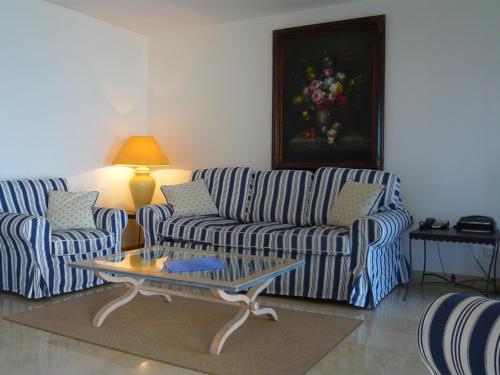 ein Wohnzimmer mit 2 Sofas und einem Couchtisch in der Unterkunft Appartement Relais de la Reine Cannes Croisette in Cannes