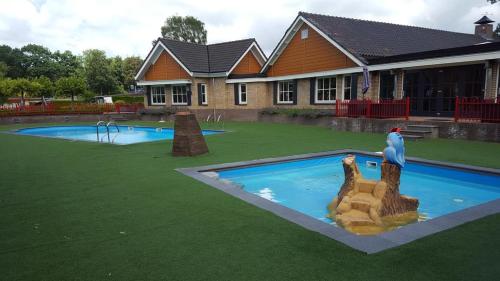 a model of a swimming pool in a yard with a house at chalet Lobke in Voorthuizen